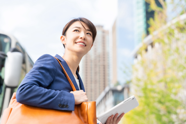 タブレットを持って通勤する女性