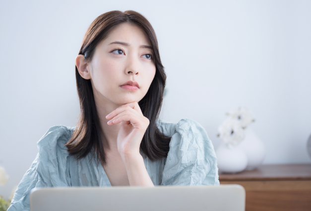 パソコンを前に考える女性